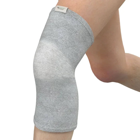 Gray knee brace on a person's knee with a white background